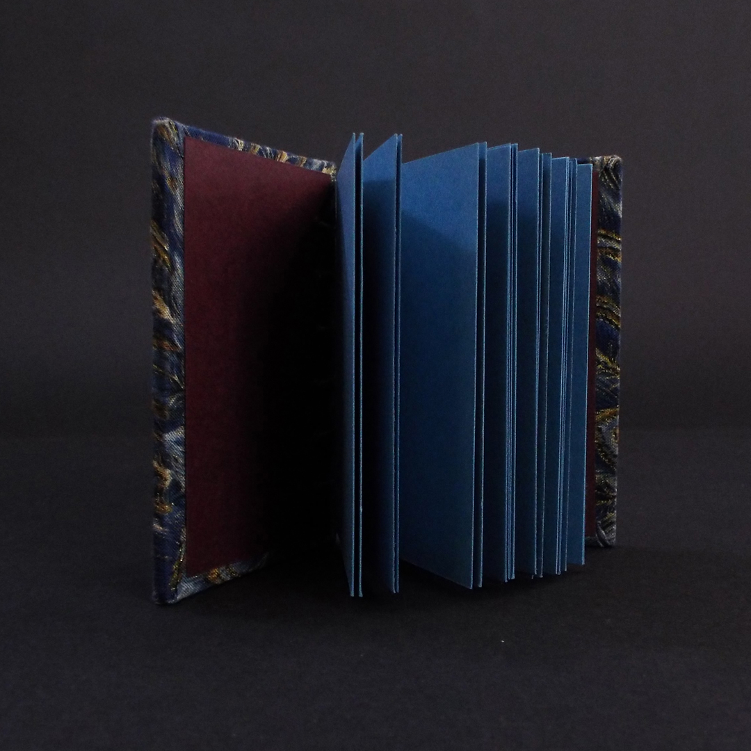 Blue peacock mini coptic bound book inside showing the blue text block and burgundy end pages