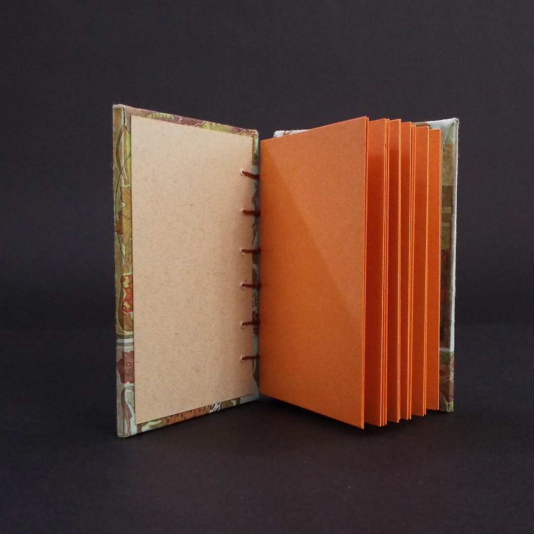 Art Nouveau Lady Coptic bound journal inside showing cream end pages and orange text block.
