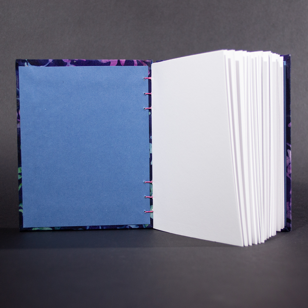 Blue Batik Vines octavo Coptic bound journal showing blue end pages and white text pages.
