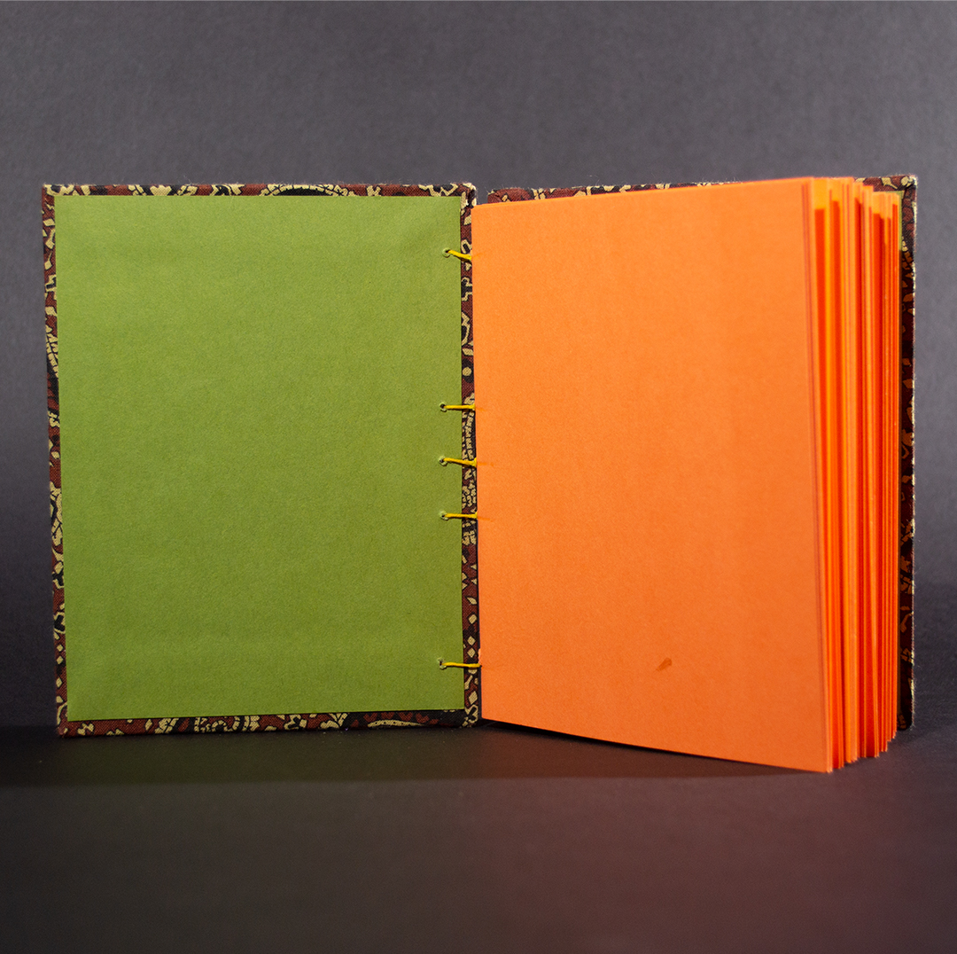 Brown paisley octavo Coptic bound journal inside shot of olive end pages and orange card stock text pages.