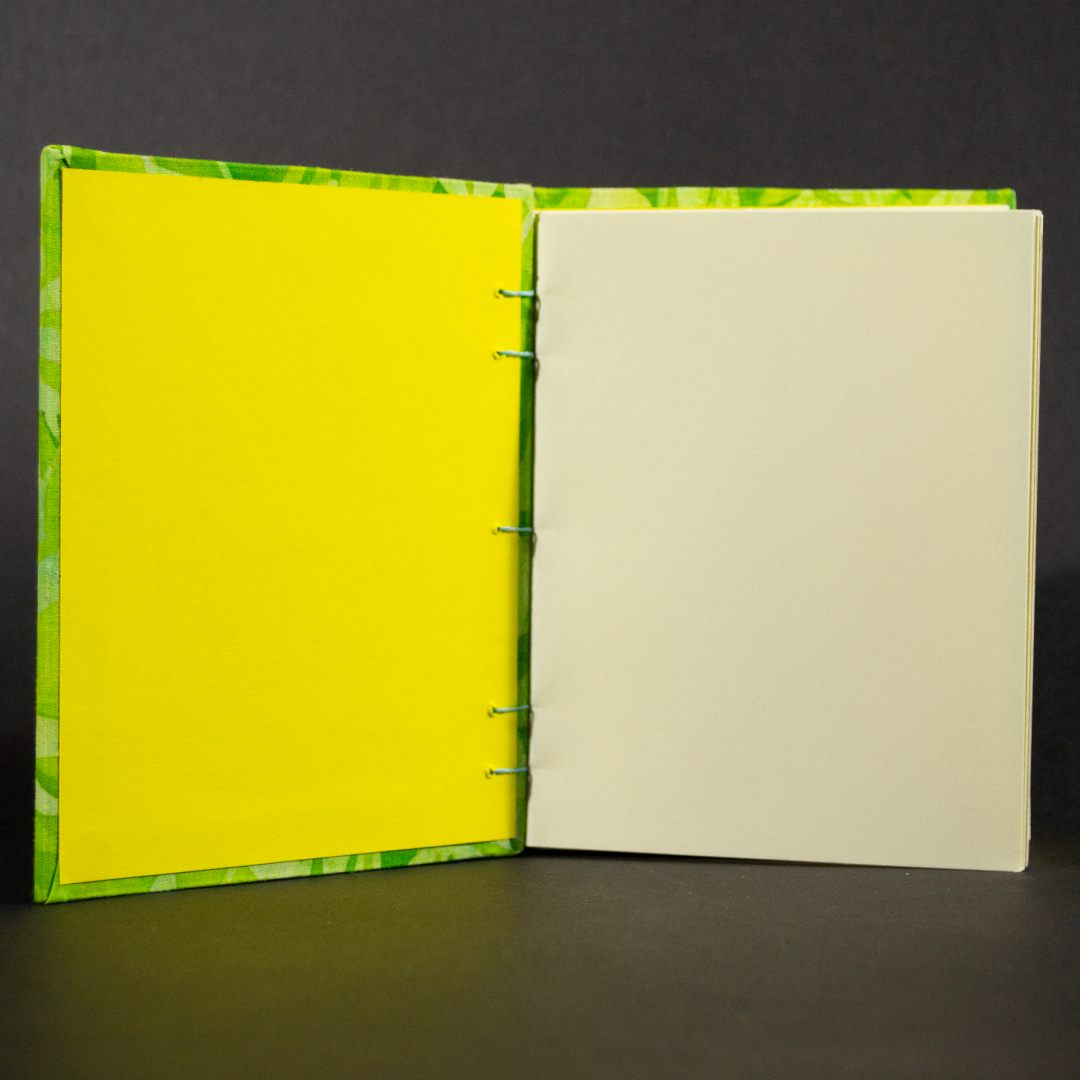 Insides of bamboo batik octavo Coptic bound journal showing ivory pages and yellow end pages