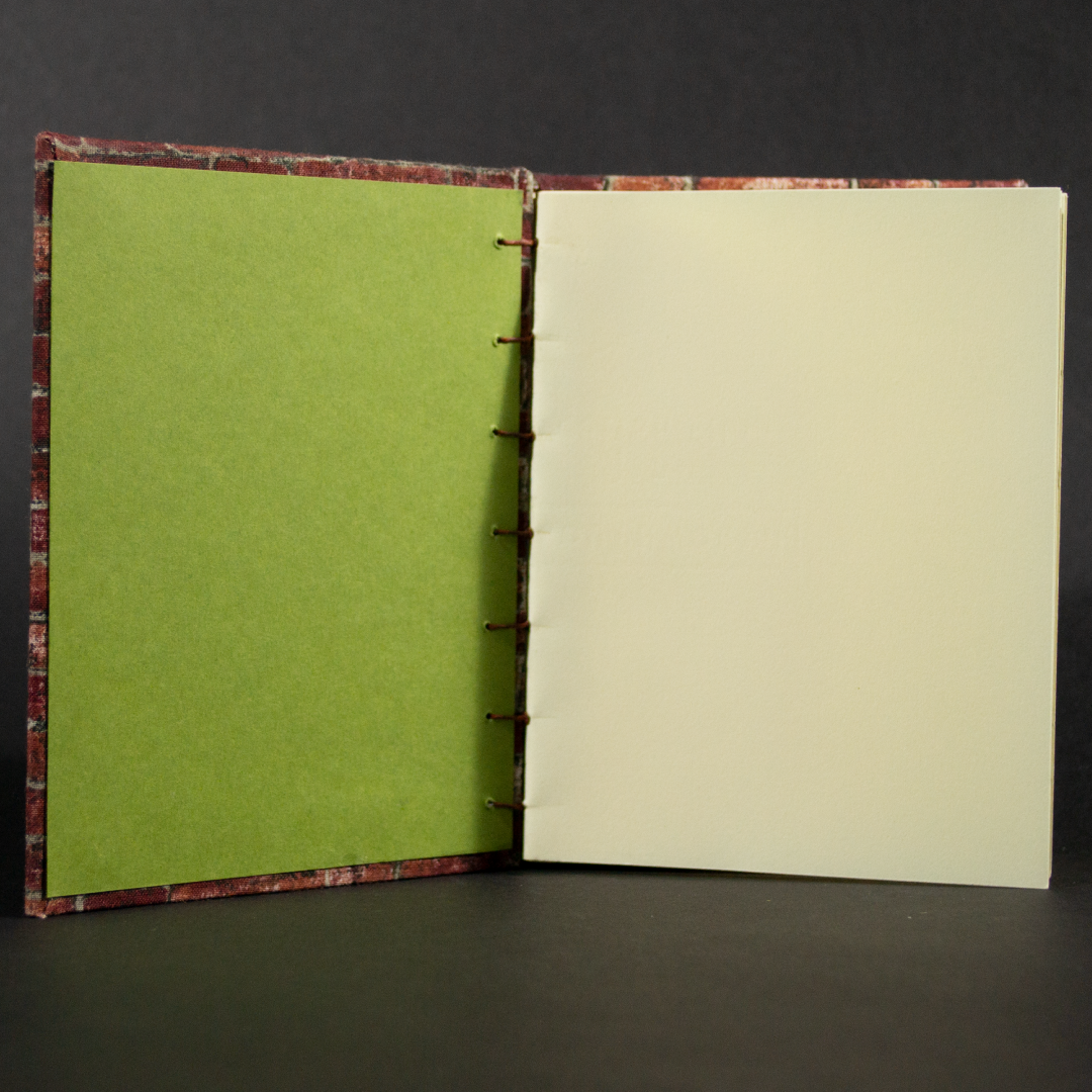 Insides of brick octavo Coptic book showing ivory cotton pages and green end pages