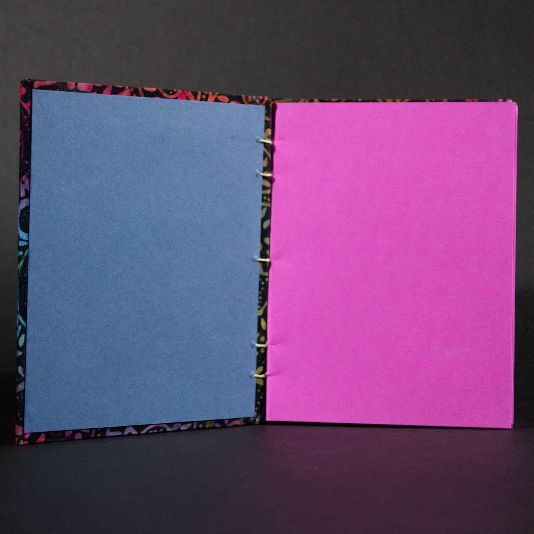 Insides of rainbow batik flowers octavo Coptic book showing the bright pink cardstock inside pages and blue end pages