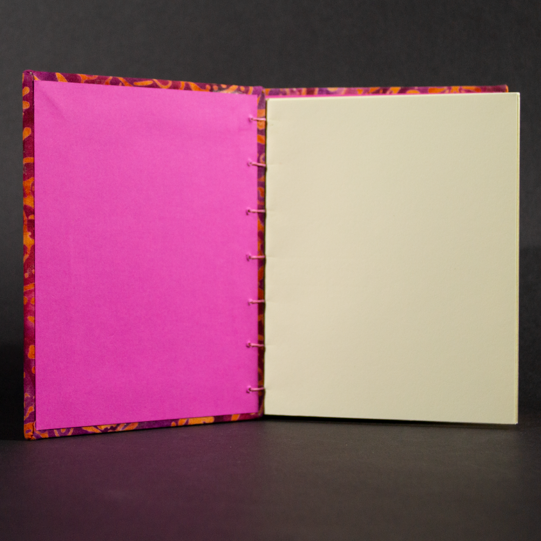 insides of orange floral batik octavo Coptic book showing ivory cotton pages and pink end pages