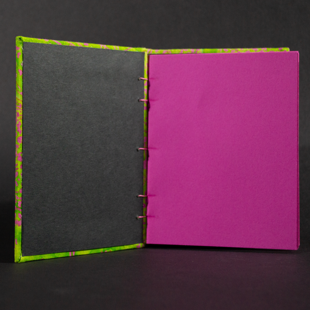 Insides of pink and green floral batik octavo Coptic book showing pink cardstock pages and black end pages