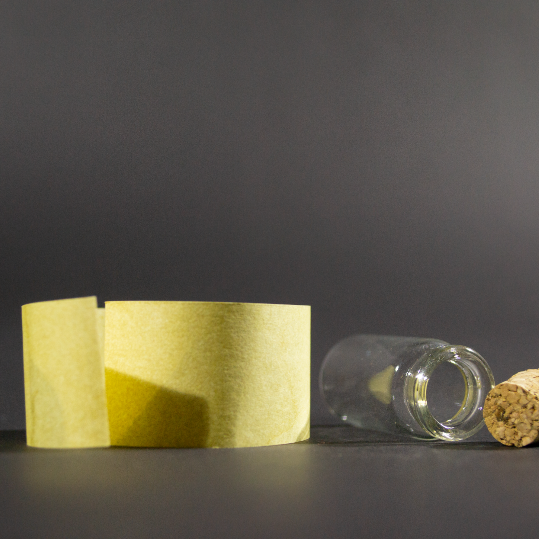 Message in a Bottle product shot showing the rolled up scroll unfurled in front of the bottle on its side next to the cork.