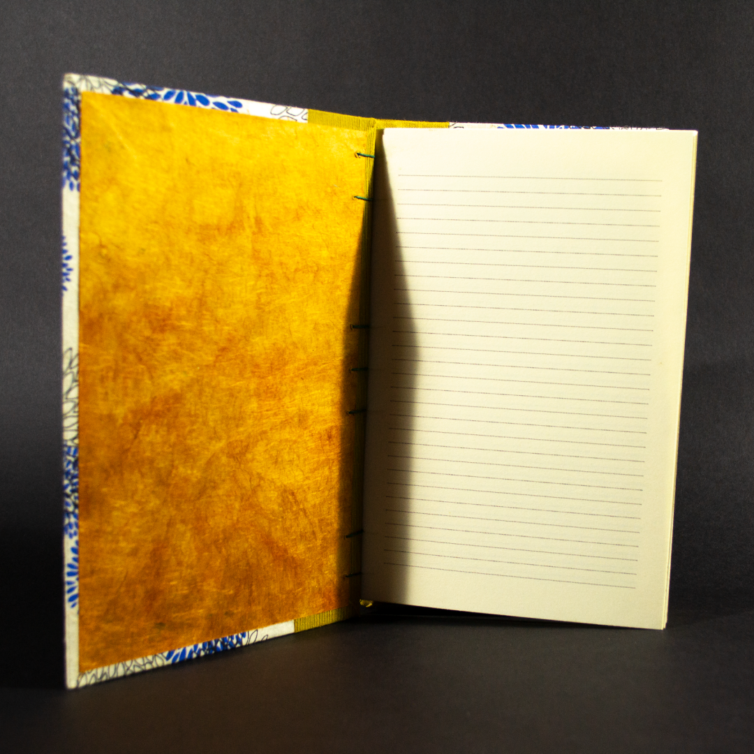 Insides of blue floral lined quarto Coptic bound journal showing orange end pages and lined ivory text pages.