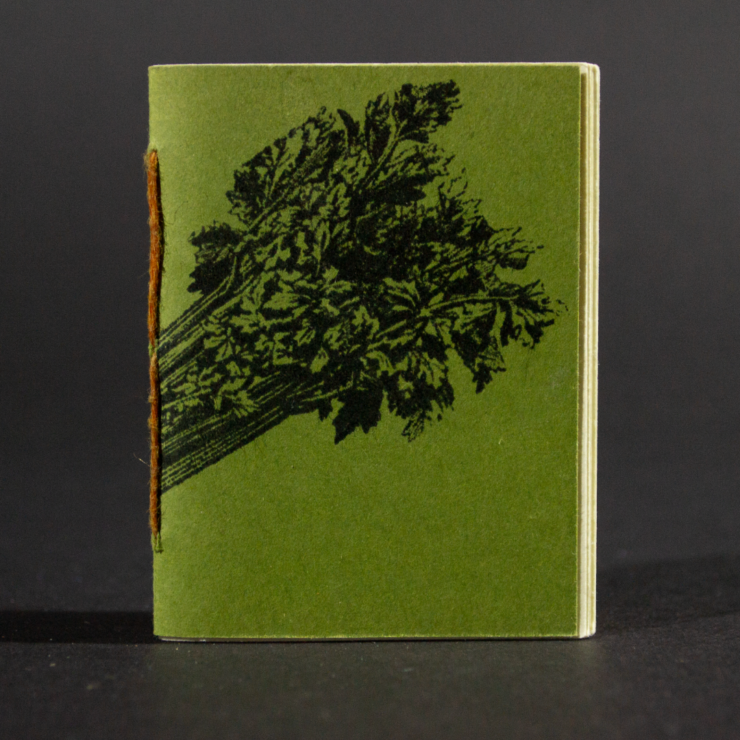 A celery stick wraps around the green front cover of this mini pamphlet book