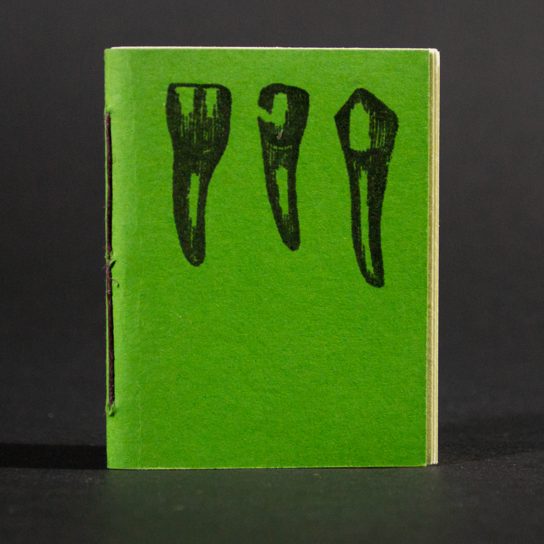 Three green teeth are on the front cover of this mini pamphlet book